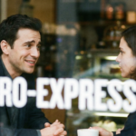 A realistic photo of a man and woman having a conversation in a cafe, with the text MICRO-EXPRESSIONS superimposed over the image to illustrate nonverbal communication.