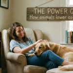 A candid photo of a smiling woman in an armchair petting a golden retriever on her lap, with a rustic wooden sign on the wall behind them that reads "THE POWER OF PETS: How animals lower cortisol levels." The room is cozy and filled with books and plants.