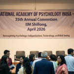 Banner and stage setup for the National Academy of Psychology India 35th Annual Convention at IIM Shillong, April 2026.